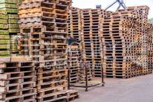 Stacks of old wooden pallets in a yard