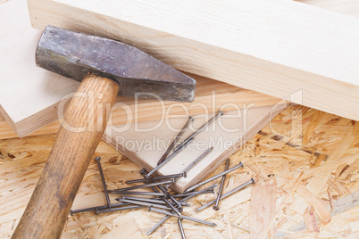 Mallet with nails and planks of new wood