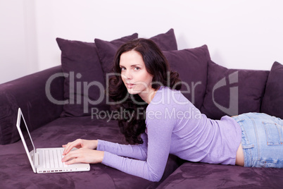 smiling woman on couch with notebook