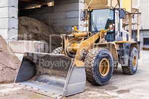 Parked pay loader near pile of dirt