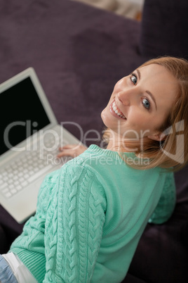 smiling woman on couch with notebook