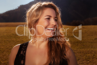 Portrait eines lachenden blonden Mädchen mit goldenem Haar.