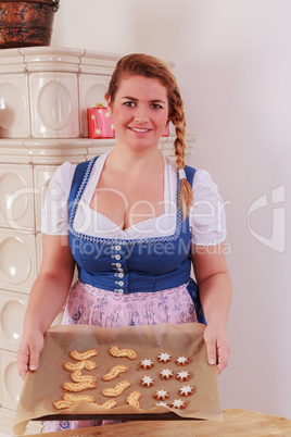 Junges Mädchen mit einem Backblech voller Kekse