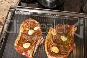 Two Steaks Marinated with Oil and Garlic on Grill