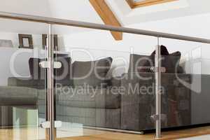 Grey Sofa Behind Metal and Glass Railing