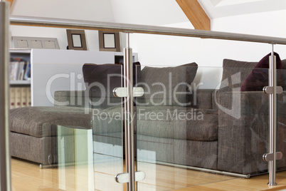 Grey Sofa Behind Metal and Glass Railing