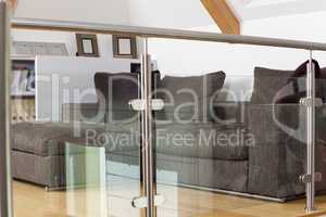 Grey Sofa Behind Metal and Glass Railing