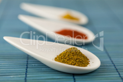 Dried ground spices in ceramic spoons