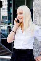smiling attractive blonde businesswoman with smartphone