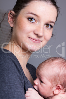 Young mother carrying infant