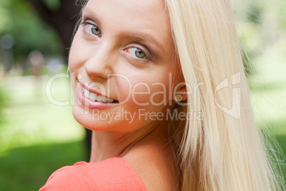 beautiful young blonde girl lying in grass summertime