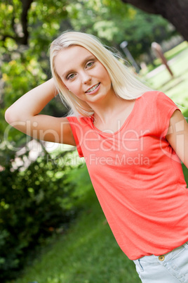 beautiful young blonde girl lying in grass summertime