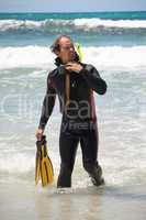 male diver with diving suit snorkel mask fins on the beach