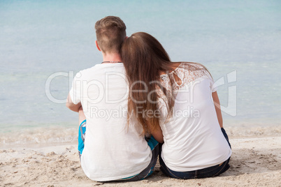 romantic young couple sitting on the beach in summer