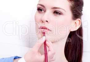 attractive woman doing make up lipliner