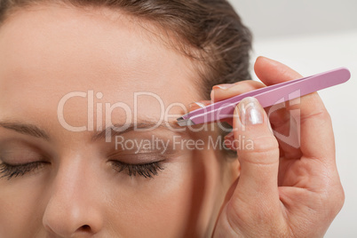 young beautiful woman eyebrow plucking tweezers eyes hair