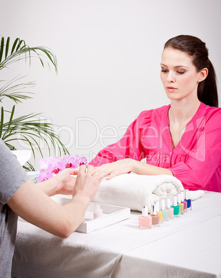 young brunette woman get manicure in salon