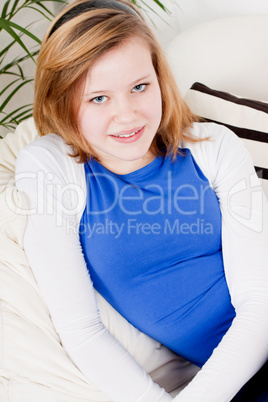 happy teenager girl smiling sitting on couch