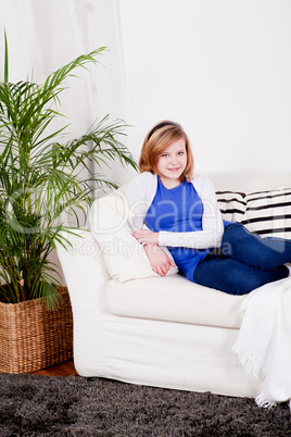 happy teenager girl smiling sitting on couch