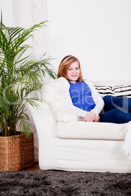 happy teenager girl smiling sitting on couch
