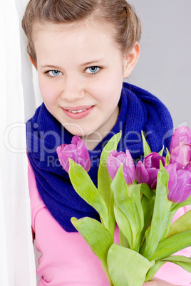 smiling teenager girl with pink tulips bouquet