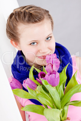 smiling teenager girl with pink tulips bouquet