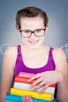 Silly smiling schoolgirl with glasses and lots of books