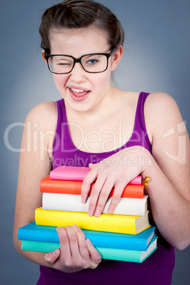 Silly smiling schoolgirl with glasses and lots of books