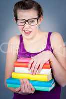 Silly smiling schoolgirl with glasses and lots of books