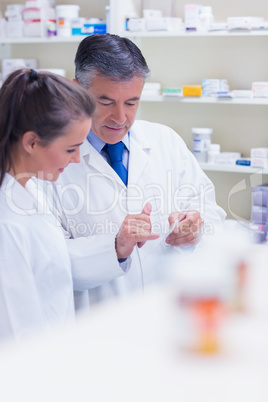 Pharmacist speaking with his trainee about prescription