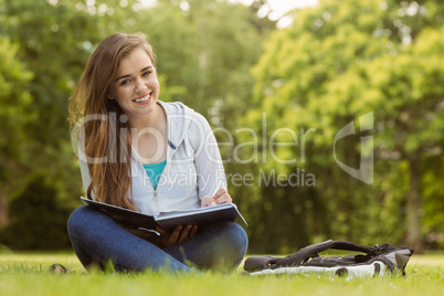 Smiling student sitting and holding book