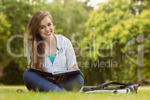 Smiling student sitting and holding book