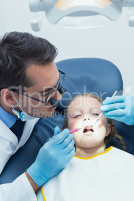 Male dentist examining girls teeth