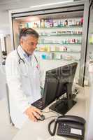 Senior pharmacist using the computer