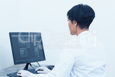 Female dentist looking at x-ray on computer