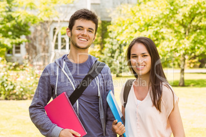 Smiling friends student standing with shoulder bag holding book