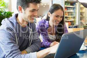 Young students doing assignment on laptop together