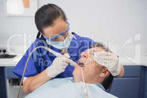 Dentist examining a patient with suction hose