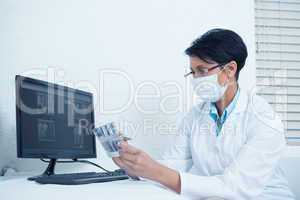 Dentist looking at x-ray by computer