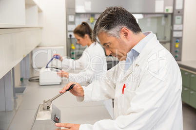 Pharmacist using press to make pills