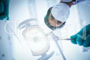 Female dentist in surgical mask holding dental tools