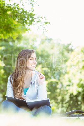 Thinking student sitting and holding book