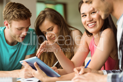 Smiling friends sitting using tablet pc