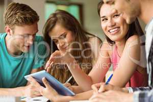 Smiling friends sitting using tablet pc