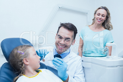 Dentist examining girls teeth with assistant Dentist examining girls teeth with assistant
