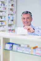Pharmacist with grey hair holding a prescription