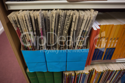 Newspapers on bookshelf in library