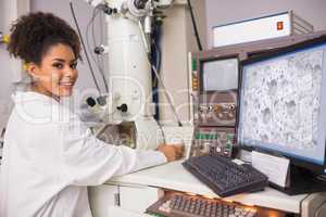 Biochemistry student using large microscope and computer