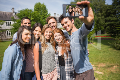 Happy students taking a selfie outside on campus