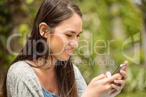 Smiling student text message on her mobile phone